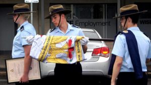 Banner Warrant Officer Cadet Flight Sergeant Benjamin Kurtz uncases the banner of No 608 (Town of Gawler) Squadron.