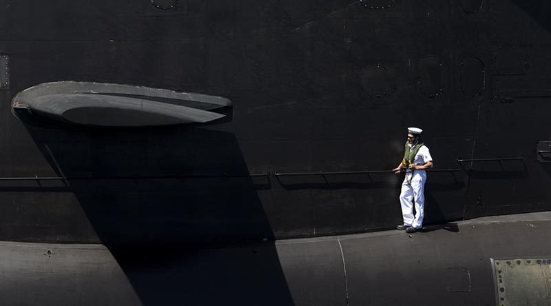 Leading Seaman Leigh Crutchley stands on the casing of HMAS Dechaineux as the boat comes alongside Fleet Base West after completing a busy few months at sea, 17 December 2016. Photo by Leading Seaman Lee-Anne Mack.