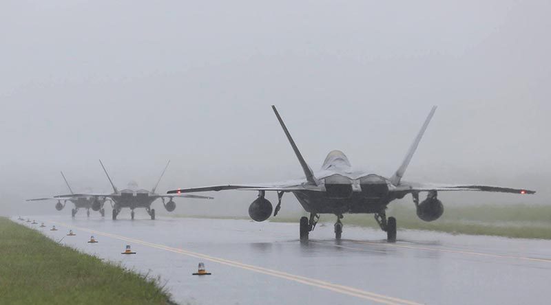 F-22s arrive at RAAF Base Tindal during a monsoonal downpour. Photo by Sergeant Andrew Eddie.