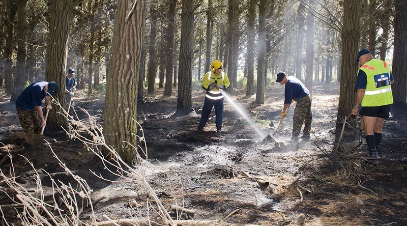 NZDF file photo: RNZAF Base Ohakea Fire Fighters putting out a smouldering fire in Raumai Air Weapons Range. The BCF (Base Contingency Force) assisted in turning over the soil to help cool down the area to stop the spread of the fire.