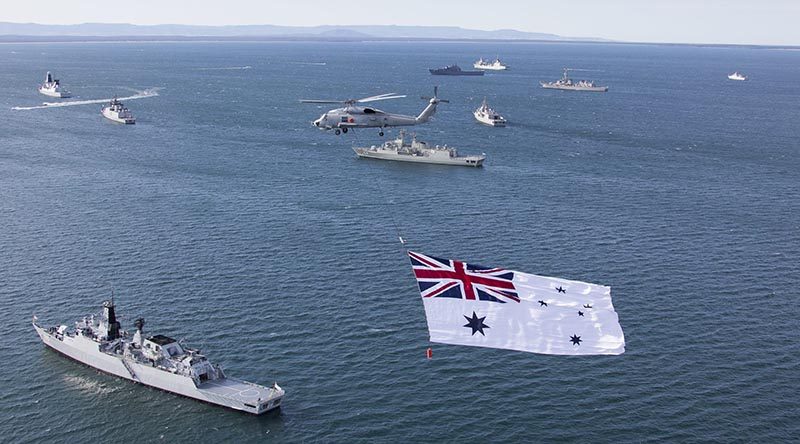 The Australian White Ensign flies over a multi-national fleet of ships at anchor in Jervis Bay. File photo by Able Seaman Sarah Williams.