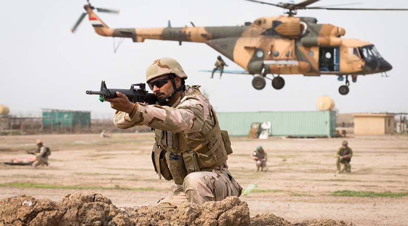 An Iraqi Army soldier provides security for an Iraqi Army Mi-17 helicopter during live-fire assault scenario with Australian and New Zealand Defence Force trainers from Task Group Taji 4 at Taji Military Complex, Iraq. Photo by Corporal Kyle Genner.