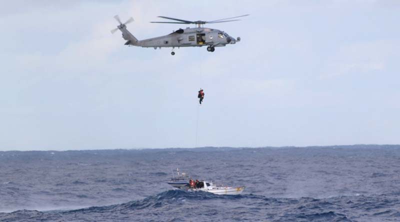 A Royal Australian Navy rescue diver from HMAS Parramatta's Seahwak Helicopter 'Blackjack' prepares to extract the three-man crew from stricken yacht 'Jedi 1'.