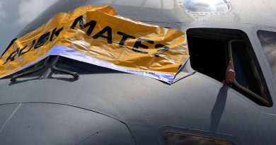 A thumbs up is given as a banner is placed across the front of an Air Force C-17A Globemaster aircraft to show support to mental health awareness on R U OK? Day at RAAF Base Amberley. Photo by Peter Longland.