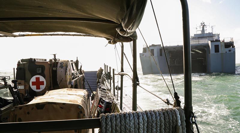 An Australian Army Bushmaster Protected Mobility Vehicle ambulance on an LCM8 landing craft exits the well dock of HMAS Choules. Photo by Able Seaman Bonny Gassner.