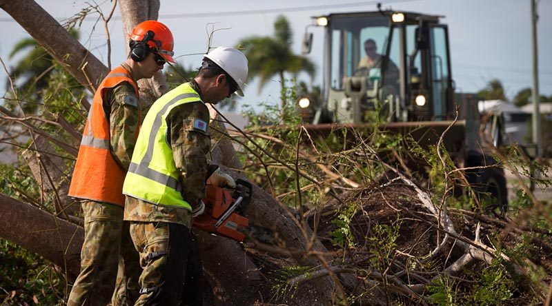 Corporal Brendan Bayly and a colleague from 3rd Combat Engineer Regiment, cuts up a fallen tree in Bowen, Queensland, in the wake of Tropical Cyclone Debbie. Photo by corporal David Said.