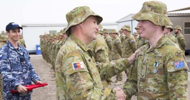 Wing Commander Philip Sexton congratulates his son Leading Aircraftman Caleb Sexton on receiving the Australian Operational Service Medal-Greater Middle East during the Theatre Communications Group (TCG) 3 medal parade in the Middle East on 20 February 2017. Photo by Corporal Bill Solomou.