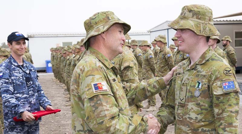 Wing Commander Philip Sexton congratulates his son Leading Aircraftman Caleb Sexton on receiving the Australian Operational Service Medal-Greater Middle East during the Theatre Communications Group (TCG) 3 medal parade in the Middle East on 20 February 2017. Photo by Corporal Bill Solomou.