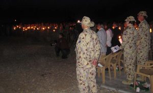 Sergeant Peter Rewko took this photo at the ANZAC Day Dawn Service at Talil, Iraq, in 2008 and sent it to CONTACT for publishing – not realising that CONTACT Editor Brian Hartigan is the civilian kneeling in centre of the picture.