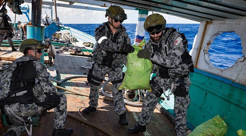 Members of HMAS Arunta's boarding party seize and account for illegal narcotics found during the search of a dhow while on patrol in the Middle East. Photo by Able Seaman Steven Thomson.
