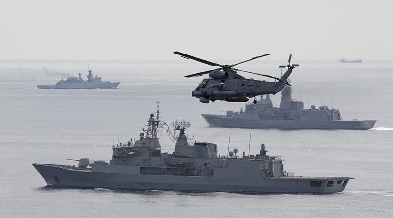 A Royal New Zealand Navy Sea Sprite flies over the formation, as warships from Australia, Malaysia, Singapore and New Zealand conduct a Photo Exercise during Bersama Shield 2017. Photo by Leading Seaman Bradley Darrell.