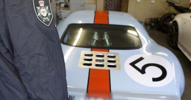 An AFP officer examines a luxury car seized in a raid on properties associated with a $165 million tax fraud. AFP photo.