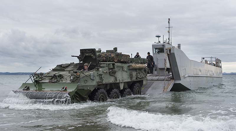 Army Corporal Robert Hosking drives a light armoured vehicle from a Navy landing craft. NZDF photo.