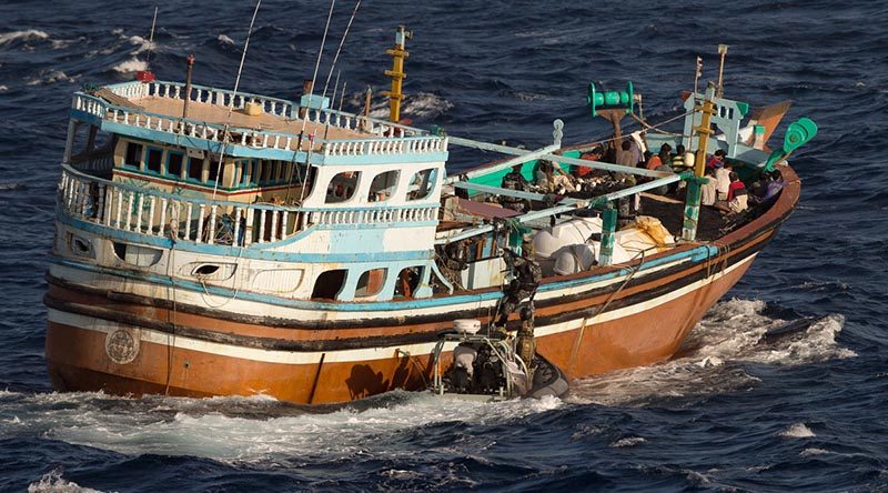 A member of HMAS Arunta's boarding party embarks a dhow smuggling illegal narcotics in the Middle East Region. Photo by Able Seaman Steven Thomson.