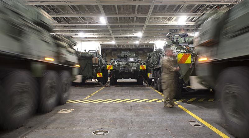 Two Light Armoured Vehicles (LAVs) are simultaneously driven into their parking spots onboard HMNZS Canterbury to be transported to Australia for Exercise Talisman Sabre.