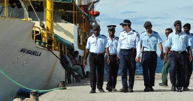 Australian Federal Police and Royal Solomon Islands Police Force patrol the dock at Honiara. AFP photo by Brian Hartigan.