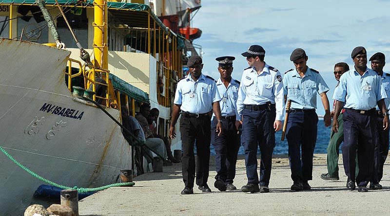 Australian Federal Police and Royal Solomon Islands Police Force patrol the dock at Honiara. AFP photo by Brian Hartigan.