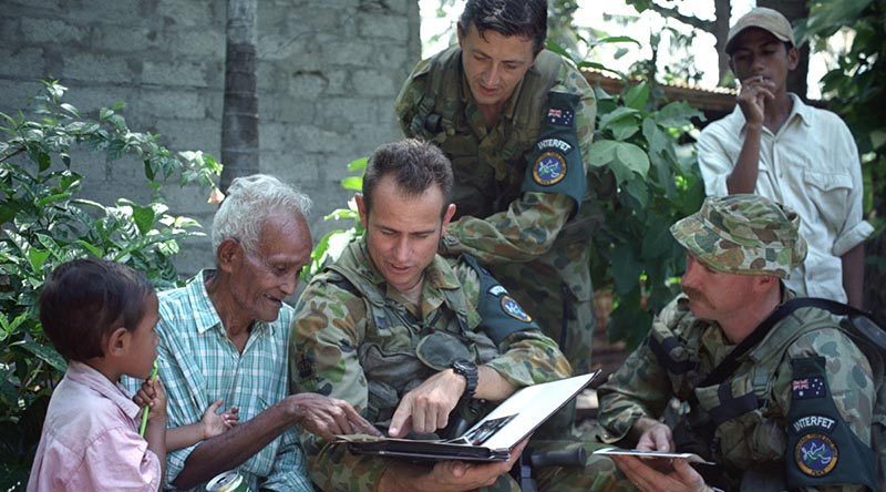 Then 75-year-old Rufino Correia, who worked with 2/2 Commando Squadron during WWII, reminisces with Australian soldiers in Dili, in 1999. Photo by Warrant Officer Class 2 Wayne Ryan.