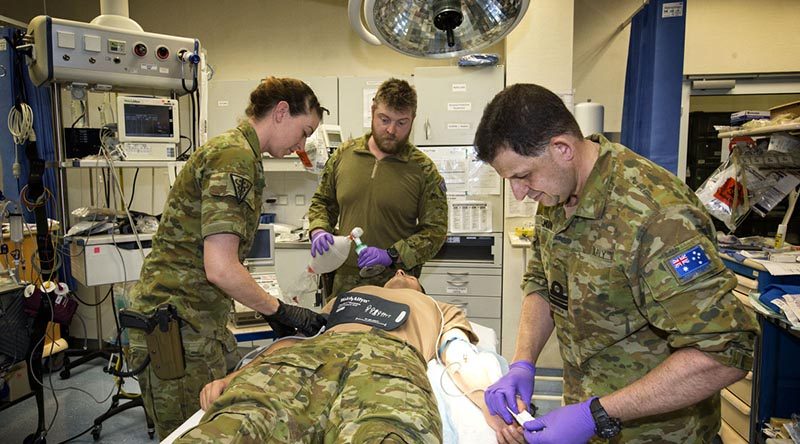 Task Group Afghanistan medics Flight Lieutenant Tessa O’Brien, Leading Seaman Peter Gough and Lieutenant Commander Gavin Milkins treat a simulated patient at the Role 2 Enhanced NATO Medical Treatment Facility at Hamid Karzai International Airport, Kabul, Afghanistan. Photo by Sergeant Ricky Fuller.