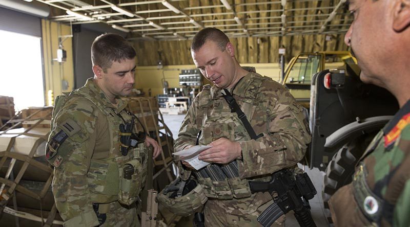 Armament Advisor to the Afghan Air Force Squadron Leader Nathan Gilmore (left) checks ammunition reserve levels with his colleagues at Hamid Karzai International Airport, Kabul, Afghanistan. Photo by Sergeant Ricky Fuller.