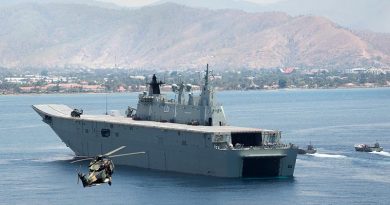 A MRH-90 Taipan helicopter delivers visitors from the Timor Leste government to HMAS Adelaide in Dili Harbour, as Navy and Army landing craft deliver a mobile hospital.
