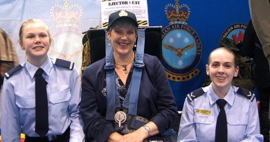 Principal of Urrbrae Agricultural High School Joslyn Fox strapped in to an ejector seat, attended by Cadet Jade Curwood (left) and Leading Cadet Ainsley Carter. Image by Flying Officer (AAFC) Paul Rosenzweig.
