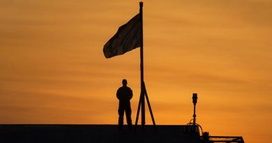 Signaller Aiden Barker prepares to lower the Australian National Flag at sunset on the Flight Deck of HMAS Adelaide while alongside Fort Hill Wharf, Darwin during Indo-Pacific Endeavour 17. Photo by Petty Officer Andrew Dakin.