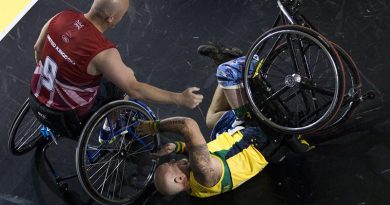 Former soldier Jeff Wright is assisted after a fall in a wheelchair basketball pool match against Denmark. Photo by Corporal Mark Doran.