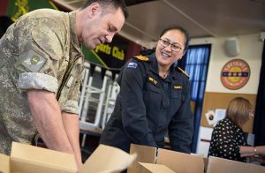 Warrant Officer of the New Zealand Army, Warrant Officer Class One Clive Douglas and Captain Melissa Ross help to pack parcels for New Zealand Defence Force personnel. NZDF photo.