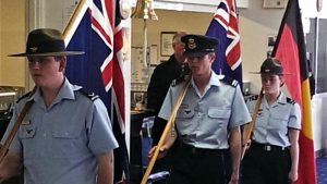 LCDT Jacob Lavery, CUO Samuel Mach and CCPL Tegan Thomas march in the New Zealand, Australian and Aboriginal Flags at the Murray Bridge RSL dining-in night.