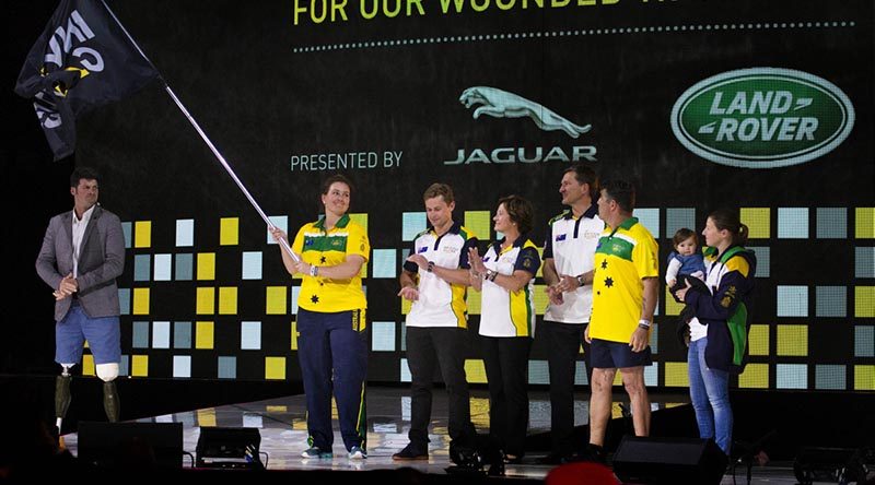 Australian team co-captains Captain Emma Kadziolka and Sergeant Peter Rutland and their families display the Invictus Games Flag after officially accepting it on behalf of Sydney, during the 2017 closing ceremony in Toronto. Photo by Corporal Mark Doran.