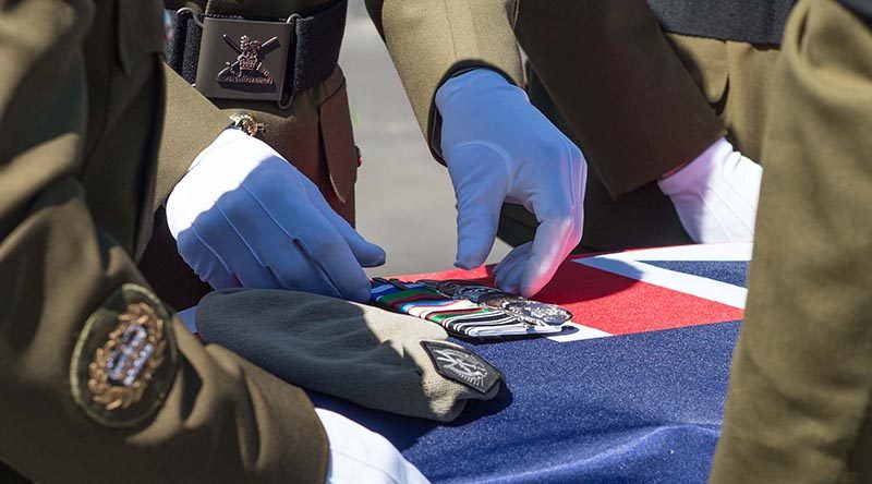 Colleagues of Sergeant Wayne Taylor place his beret and medals on his casket during a private service at Papakura Military Camp, Auckland, New Zealand. NZDF photo.