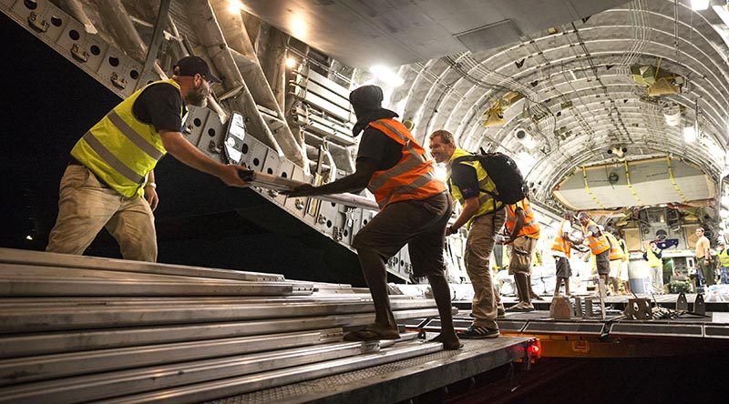 RAAF personnel are assisted by Department of Foreign Affairs and Trade, Palladium workers and Vanuatu locals to unload Australian Aid supplies from a C-17 Globemaster at Santo-Pekoa International Airport in Vanuatu as part of Operation Vanuatu Assist 2017. Photo by Leading Seaman Jake Badior.