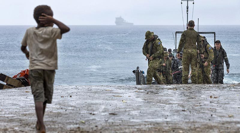 A local boy on Pentecost Island in Vanuatu greets sailors and soldiers from HMAS Choules during Operation Vanuatu Assist 2017. Photo by Able Seaman Jake Badaior.