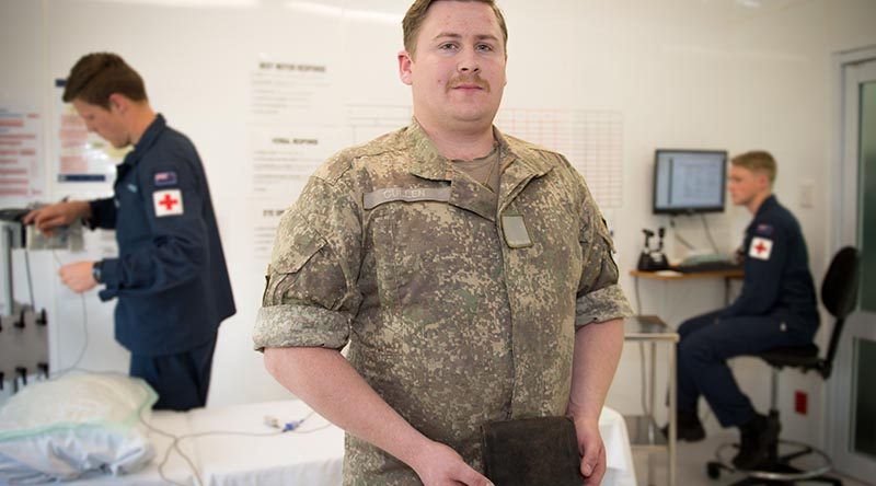 Private Hayden Cullen, New Zealand Army Band, holds a WWI wallet given to his grandfather by a German officer. NZDF photo.