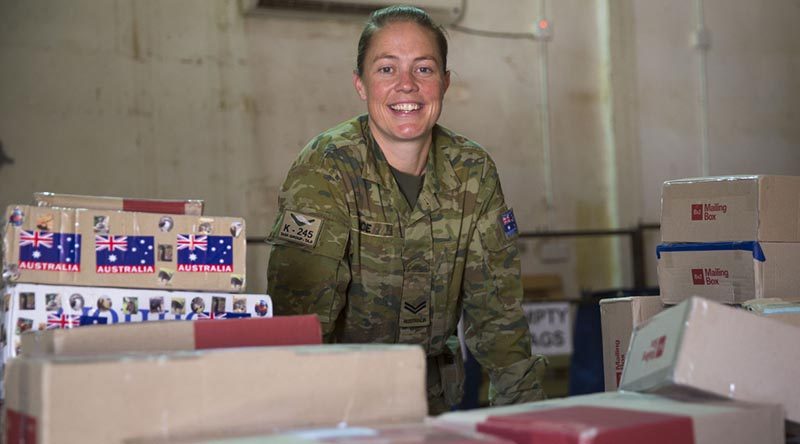 Task Group Taji postie Australian Army soldier Corporal Cassandra Rice is surrounded by work in the mail room at the Taji Military Complex, Iraq. Photo by Able Seaman Chris Beerens.