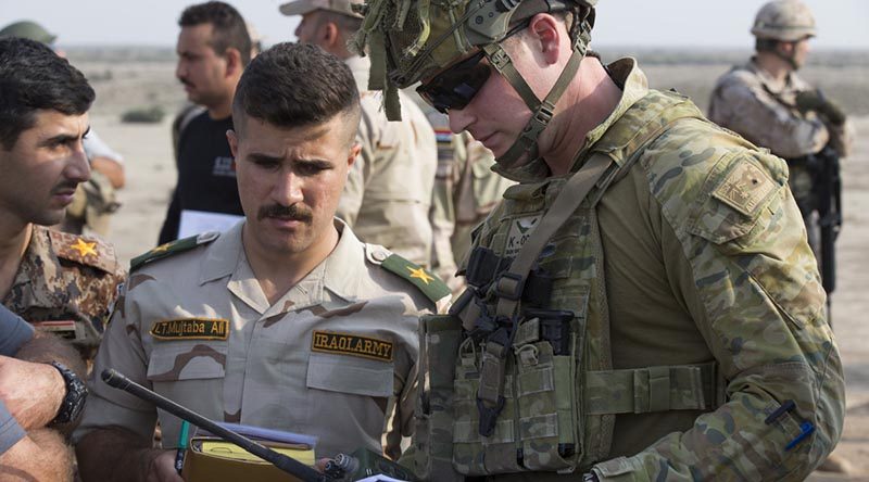 Australian Army officer Captain Nicholas Waugh confirms range and target coordinates with an Iraqi Army officer during a Forward Air Controller course live-fire component at Besmayah Range, Iraq. Photo by Corporal Chris Beerens.