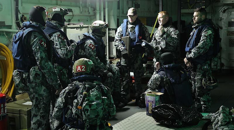 Chief Petty Officer Thomas Whitworth briefs HMAS Melbourne's boarding party during a tri-lateral exercise with United States and Republic of Korean Navies off the Korean coast. Photo by Able Seaman richard Cordell.