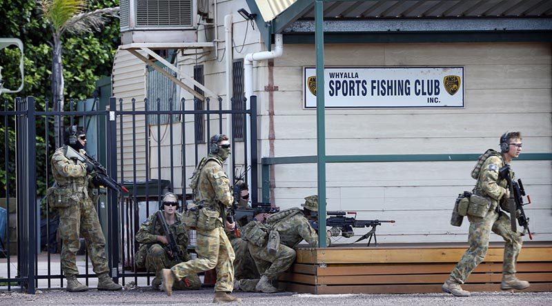 Royal Military College Staff Cadets approach the Whyalla Sea Rescue Centre to clear a 'hostile enemy'. Photo by Sergeant W Guthrie.