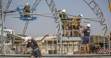 Airfield Engineers use elevated work platforms to insert cross bracing while constructing aircraft flightline shelters in the Middle East Region. Photo by Corporal Brenton Kwaterski.
