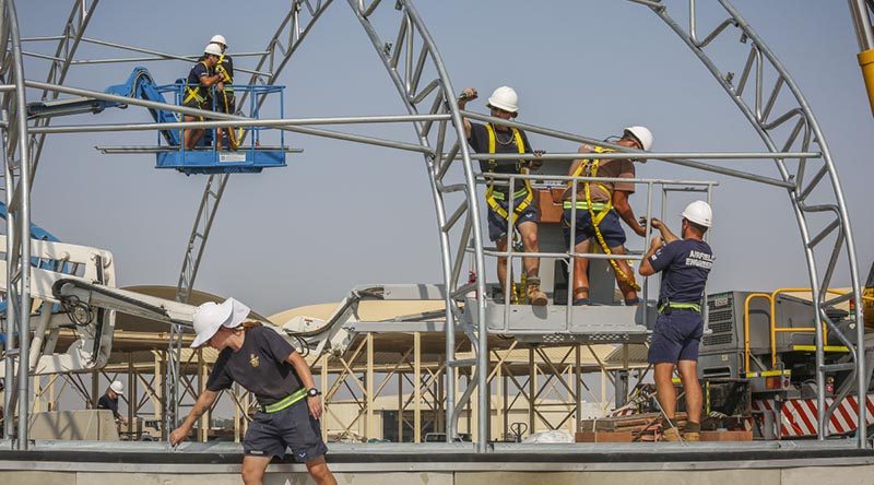 Airfield Engineers use elevated work platforms to insert cross bracing while constructing aircraft flightline shelters in the Middle East Region. Photo by Corporal Brenton Kwaterski.