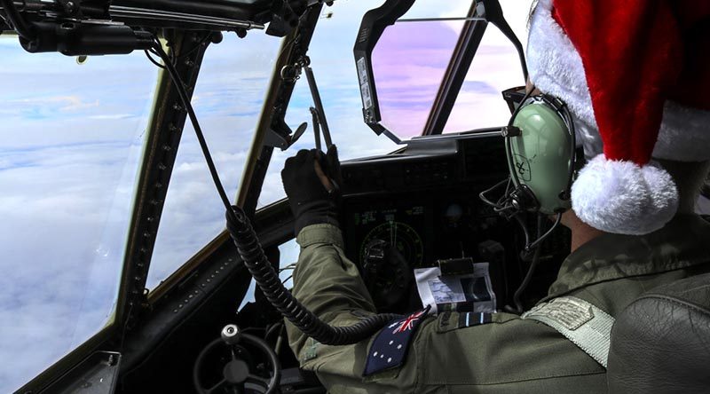 Royal Australian Air Force Flight Lieutenant Omar Rigo, 37 Squadron pilot, flies a Royal Australian Air Force C-130J Hercules toward Micronesian islands during Operation Christmas Drop. US Air Force photo by Staff Sergeant David Owsianka.