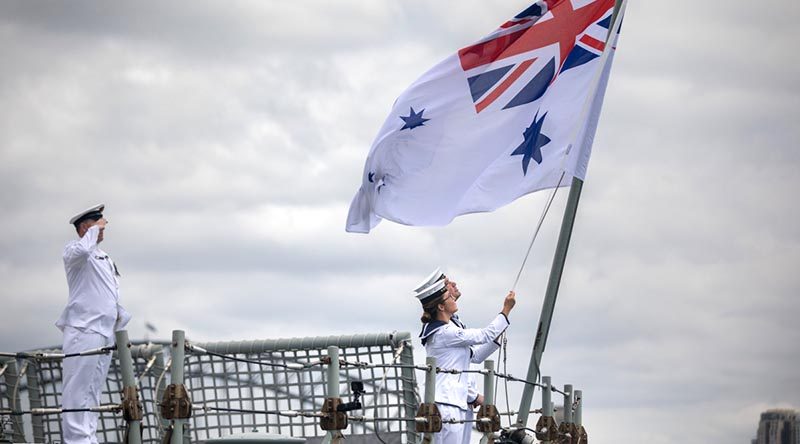 Able Seaman Samuel Millar and Able Seaman Alice Saunders lower HMAS Darwin’s Australian White Ensign for the last time. Photo by Leading Seaman Kayla Hayes.