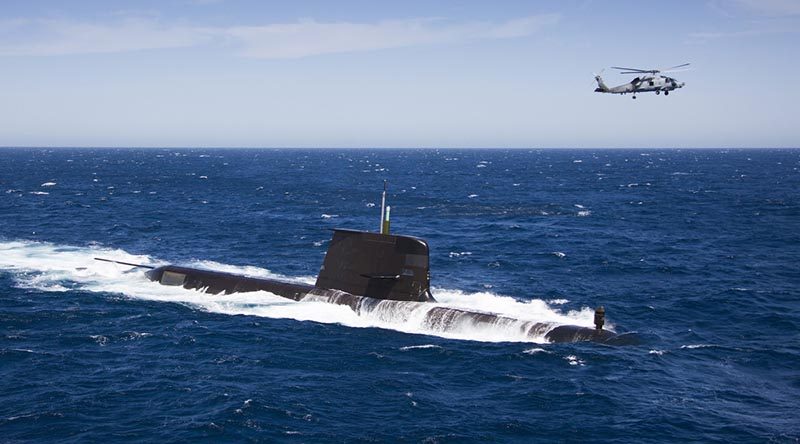 An MH-60R 'Romeo' helicopter passes HMAS Rankin in the Eastern Australian Exercise Area. Photo by Leading Seaman Sarah Williams.