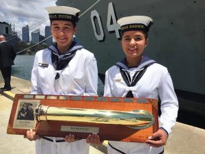 HMAS Success' Seaman Morgan Wilson-Ward, receives the First Lady of the Fleet honour board from HMAS Darwin’s youngest female sailor, Seaman Letitia Jarvis-Soars.