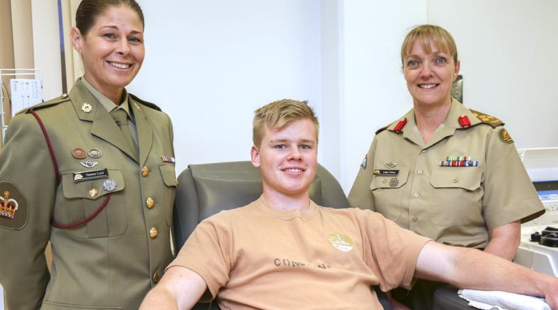 Army Blood Ambassador, Warrant Officer Class Two Geneen Lord and Brigadier Leigh Wilton provide encouragement to Officer Cadet Don Considine as he donates plasma during the Defence Blood Challenge, in Canberra on 1 September 2017. Photo by Corporal Bill Solomou.