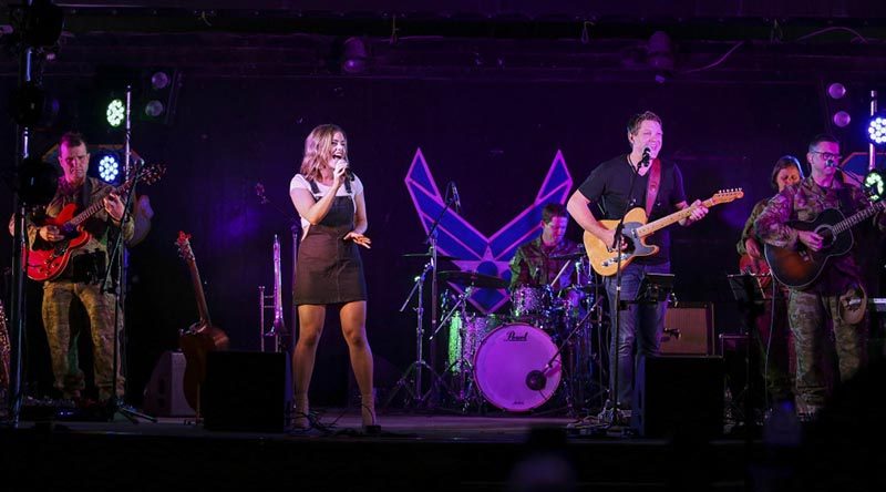 Forces Entertainment Tour members Victoria Darke and Brad Bergen belt out a tune with the Australian Army band at the main air operating base in Australia's Middle East. ADF photo.