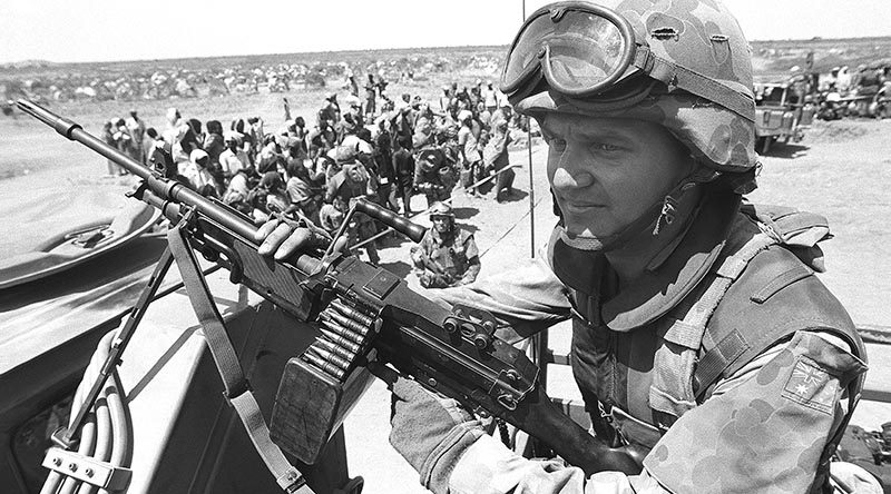 Private AJ Shinner, 1RAR, stands guard over a food-distribution point near Baidoa. Photo by Corporal Gary Ramage – 21 Jan 1993.