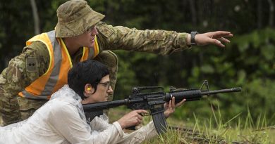 Australian Army officer Lieutenant Patrick Ingram supervises his civilian employer, Anita Gordon, as she prepares to fire an M4 carbine during Exercise Boss Lift in Malaysia. Photo by Sergeant Janine Fabre.
