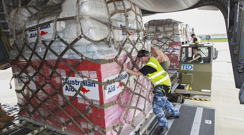 RAAF Amberley air-load team members load pallets of Australian Aid onto a RAAF C-17A Globemaster for delivery to Tonga. Photo by Sergeant Peter Borys.